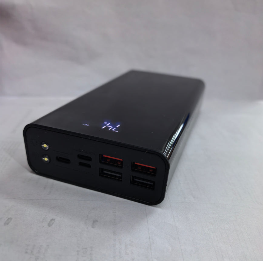 Powerbank z wyświetlaczem LCD obok telefonu